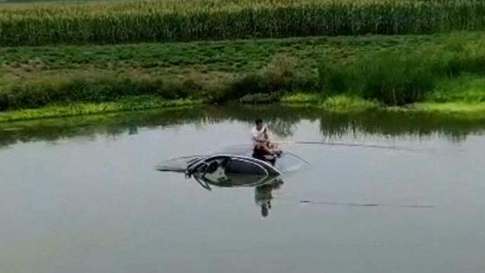 男子驾车失控冲进水塘，坐车顶“淡定”钓鱼