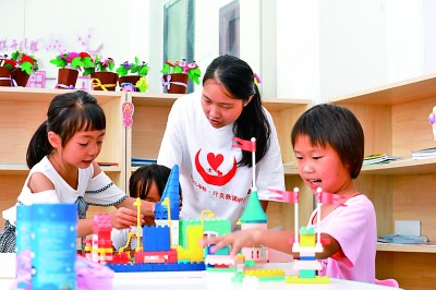 在贵州剑河县思源社区，来自南昌大学人文学院的大学生志愿者和该社区的孩子在玩游戏。杨家孟摄/光明图片