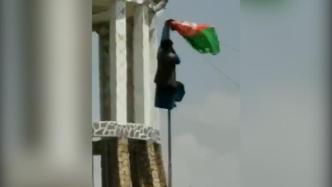 塔利班宣布建国后，喀布尔民众爬杆悬挂阿富汗国旗