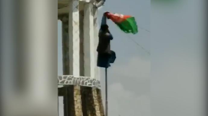 塔利班宣布建国后，喀布尔民众爬杆悬挂阿富汗国旗