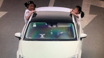 女司机打电话驾车两孩子探出车窗手扒车顶，被罚款50元