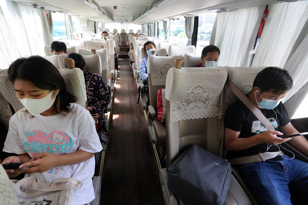 2021年8月26日,南京汽车客运站(小红山站)恢复运营首日,乘客戴口罩检票后,乘坐客运大巴。南京将继续保留30处“环苏”公路离宁查验点和39处入宁查验点,对中高风险地区的“来宁”和“离苏”车辆及驾乘人员进行查验管控,14个高速公路收费站出入口继续实施管控;继续做好7处水路查验点的进港查验、过境管控和锚地管控。