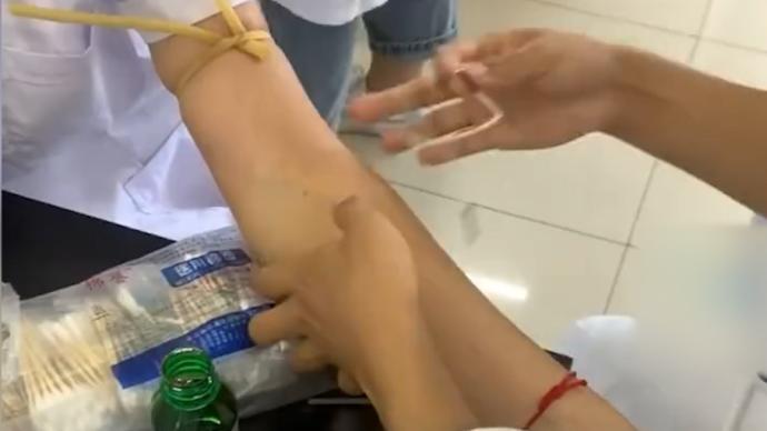 医学生在同学手臂上练习采血,紧张到针被弹飞