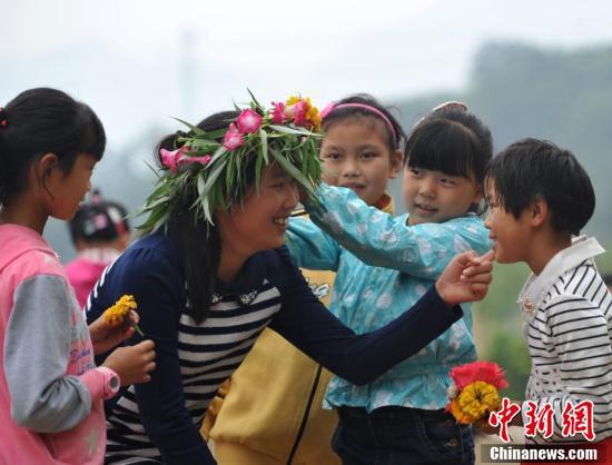 资料图：孩子们亲手编花环祝贺老师节日快乐。中新社记者 翟羽佳 摄