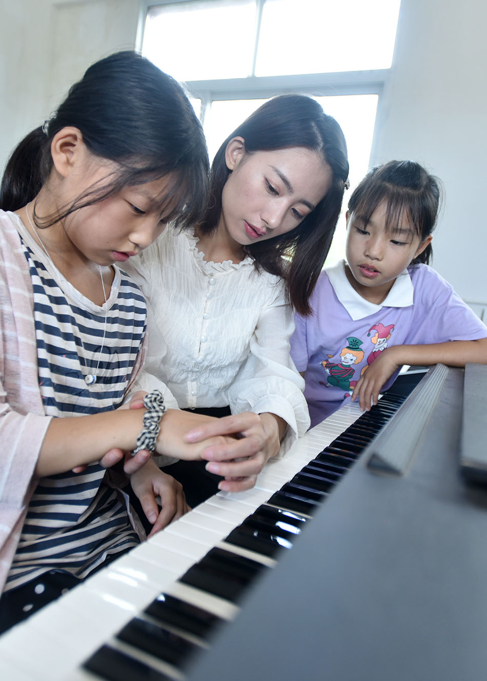 四川省内江市东兴区杨家镇石盘寨小学,林玲在指导学生学习弹钢琴