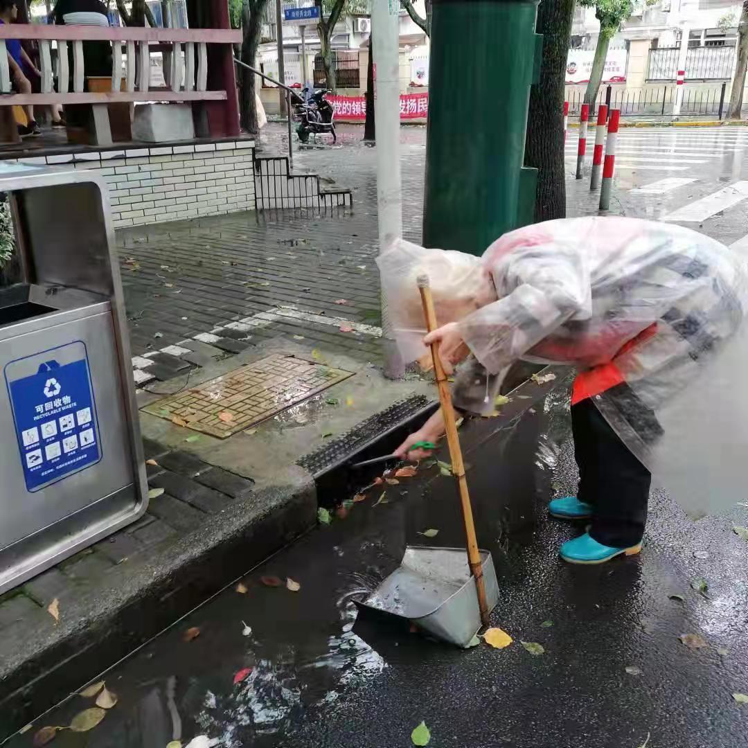 环卫工人清扫杂物,防止下水道堵塞。