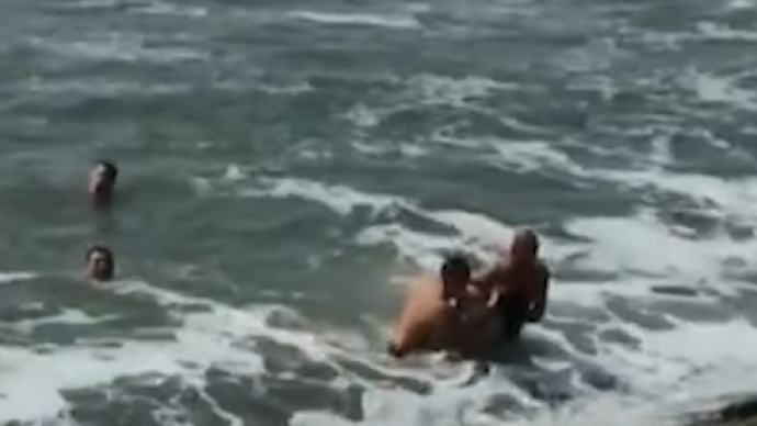 游客越过警戒线拍照坠海，两男子跳海相救