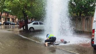 消防栓被撞喷出高压水柱，上海女民警冒险搬石化险情