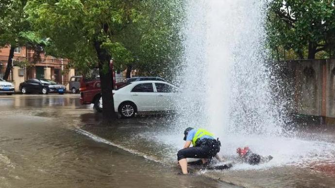 消防栓被撞喷出高压水柱，上海女民警冒险搬石化险情