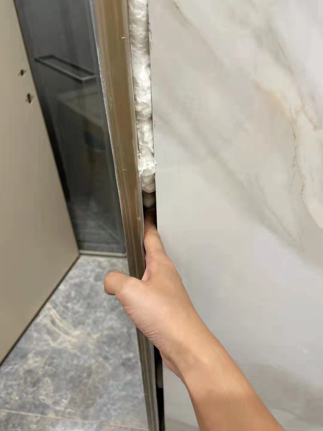 王女士家客卫门门缝过大,缝隙能容一手指.