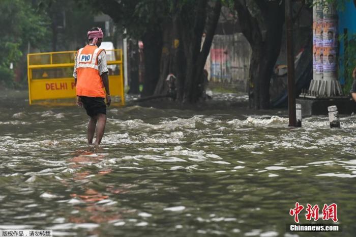 当地时间9月11日，印度新德里，一场暴雨过后路面积水严重，市政工人正在疏通排水设施。 资料图