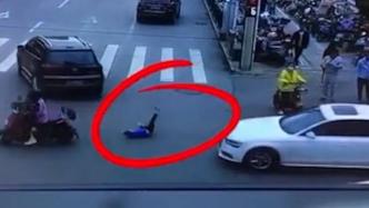 孩子反坐电动车摔下被卷入车底，众人抬车救人