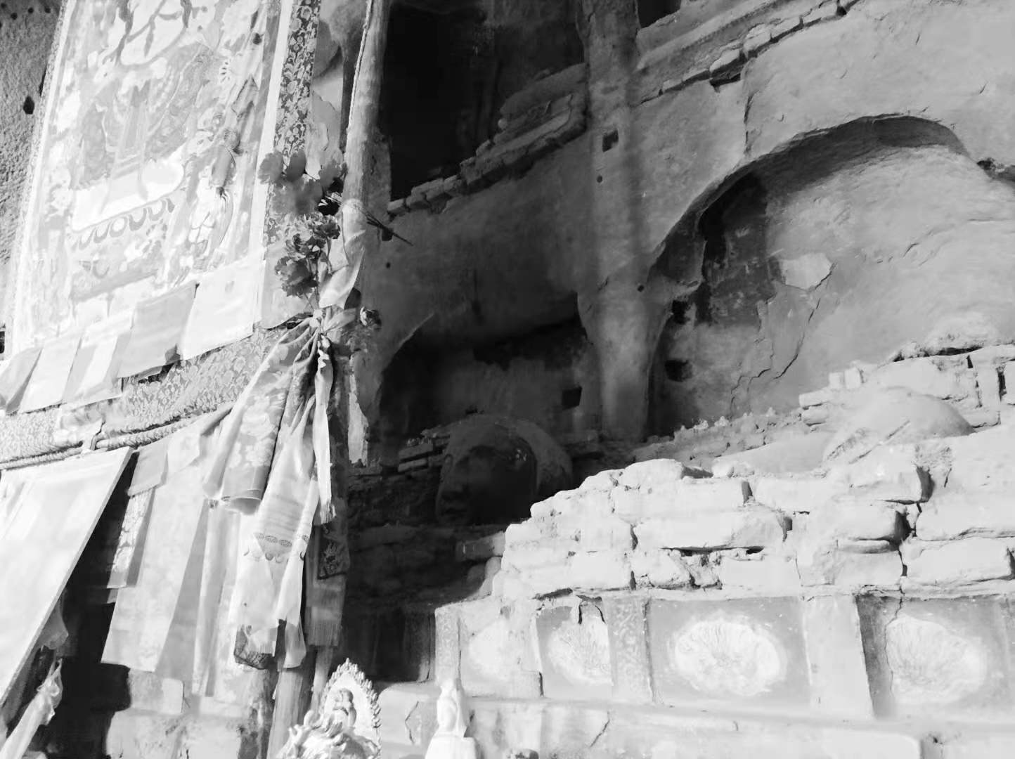 马蹄寺石窟内被画挡住的部分，台子上摆放着一颗佛头，身子没了。