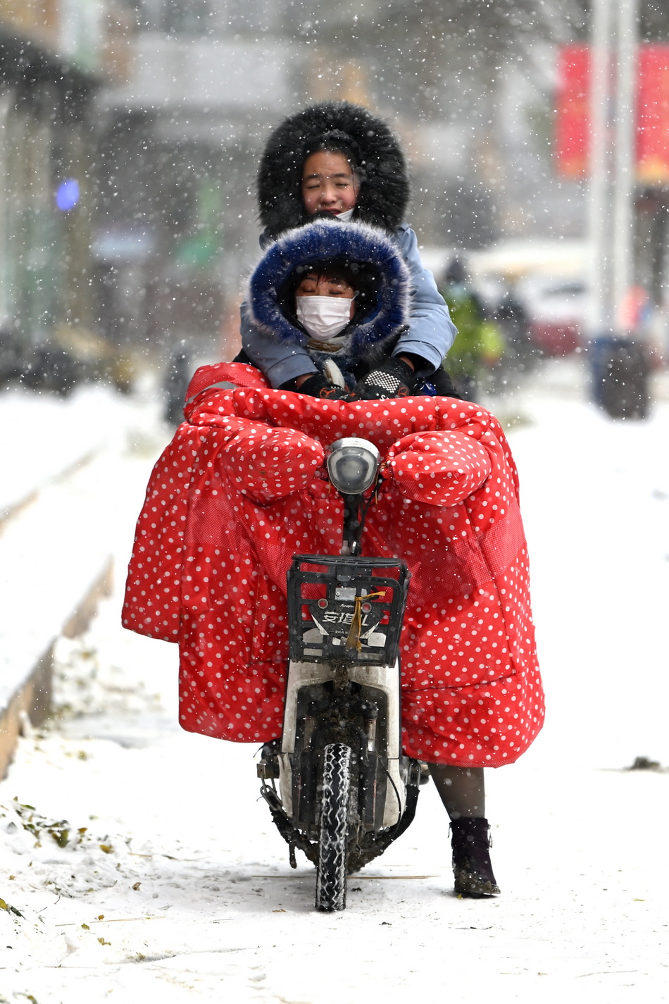 2021年11月6日,内蒙古自治区呼和浩特市,民众在雪中出行。当日,当地气象部门分别发布道路结冰黄色预警、大风蓝色预警、暴雪蓝色预警。