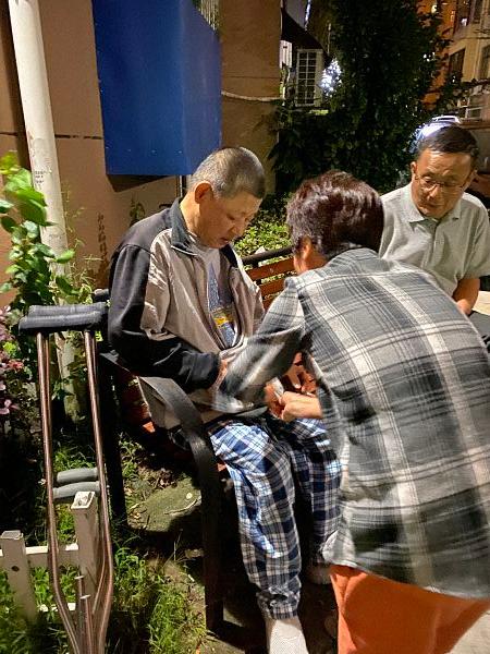 赵文龙吃完饭在小区散步时，谌孟珍给他拉好拉链。澎湃新闻记者 陈灿杰 图