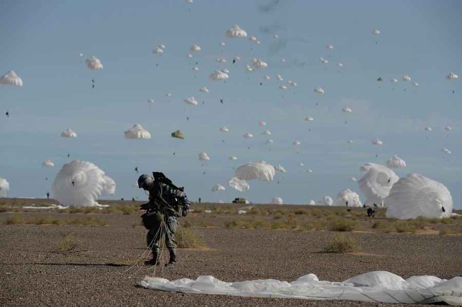 某演习日，一名空降着陆的空降兵正在快速解脱伞具。