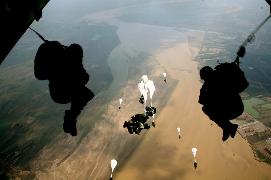 空降兵特战队员在中原某地黄河滩涂进行水上跳伞训练，全方位锤炼官兵在复杂环境条件下空降作战能力。