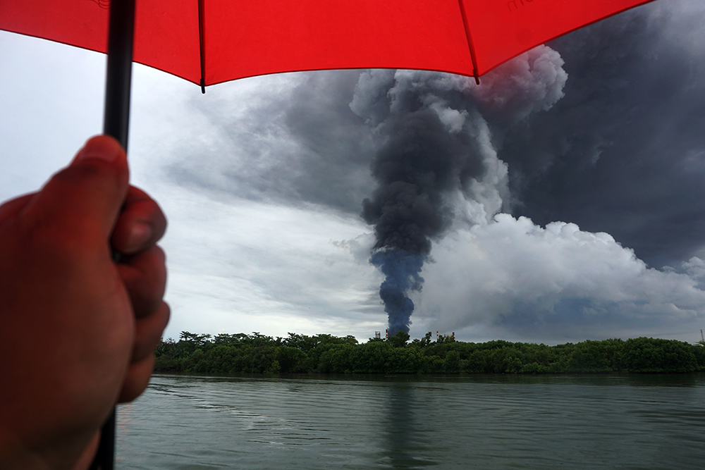 当地时间2021年11月14日，印度尼西亚芝拉扎，国家石油公司Pertamina燃烧的油罐升起浓烟。