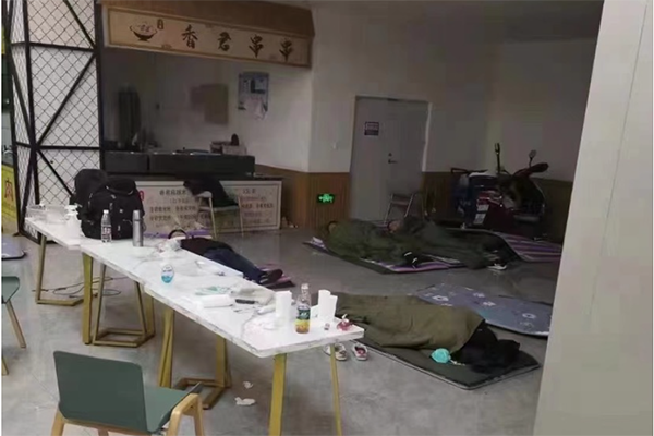 11月8日，庄河大学城东区，志愿者在食堂打地铺休息。受访者供图