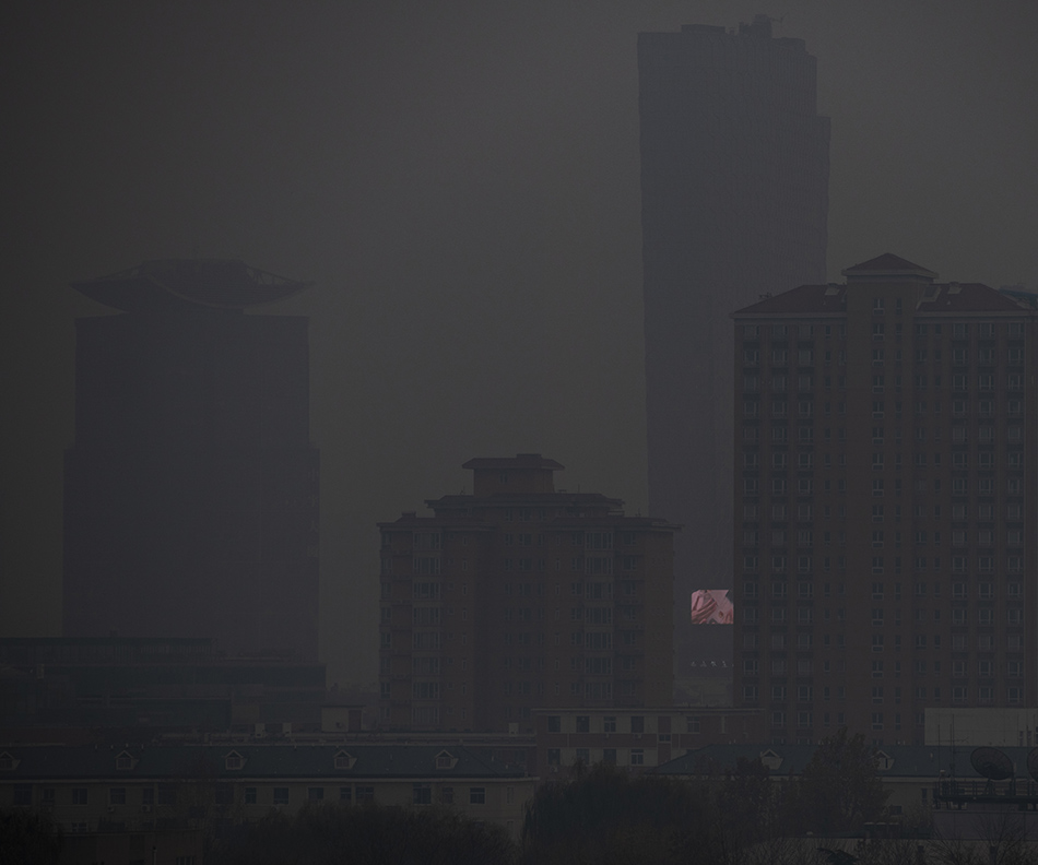 2021年11月18日，北京三里屯，受大雾天气影响，城市被浓雾笼罩，楼宇间的电视屏在浓雾中闪烁。当日早上，北京通州、大兴等多区升级发布大雾橙色预警信号，局地能见度小于200米。潘松刚/视觉中国 图