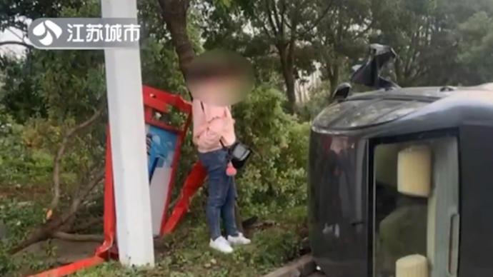女子开车时捡手机，车辆失控撞上绿化带