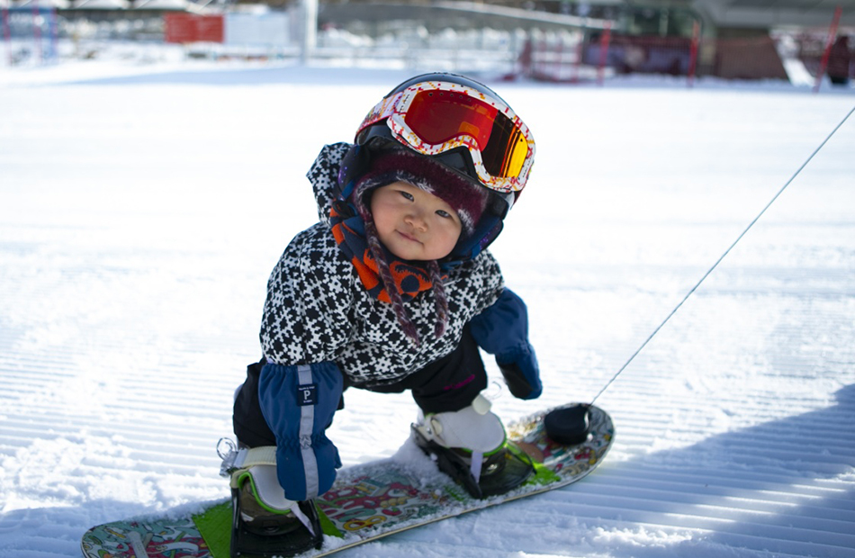 2021年11月18日，11个月大的萌宝王予玑在滑雪。因为父母近期在崇礼学滑雪，她迎来了人生首次单板滑雪之旅，“不会走路就能滑雪”的视频上传到社交媒体后，引来广泛关注。张帆/新华社 图