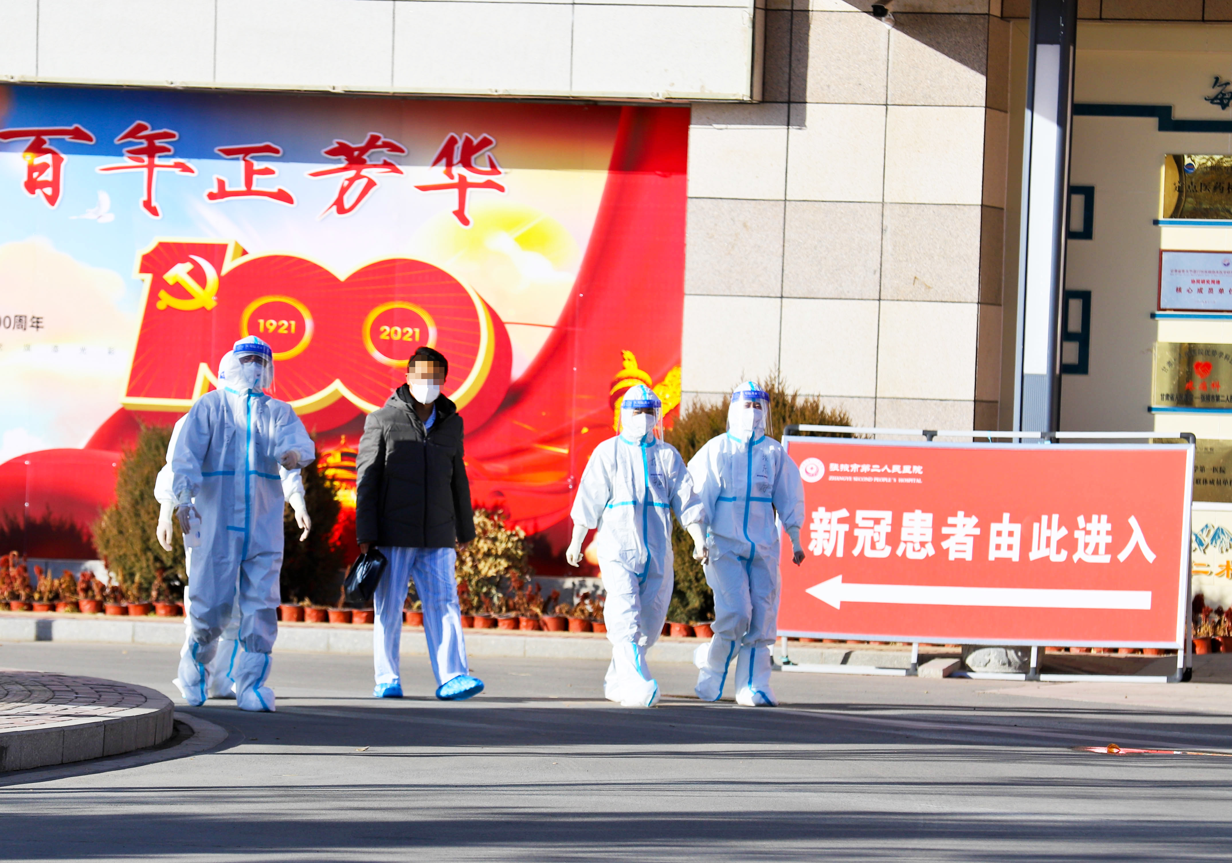2021年11月21日下午，甘肃张掖市第二人民医院收治的又一名新冠肺炎患者治愈出院，离开时医护人员送他们到医院门口。王将/人民视觉 图