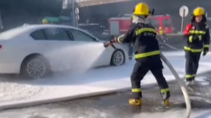 车辆自燃汽油泄漏形成流淌火，消防员演习路上顺手救援