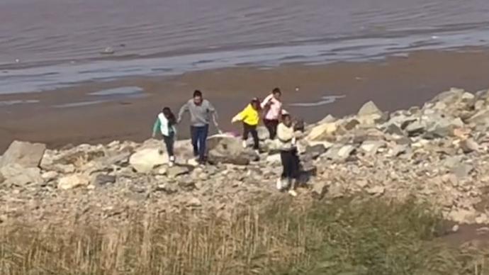 游客海边玩耍不知将涨潮，路过救援队员将他们“吼”上岸