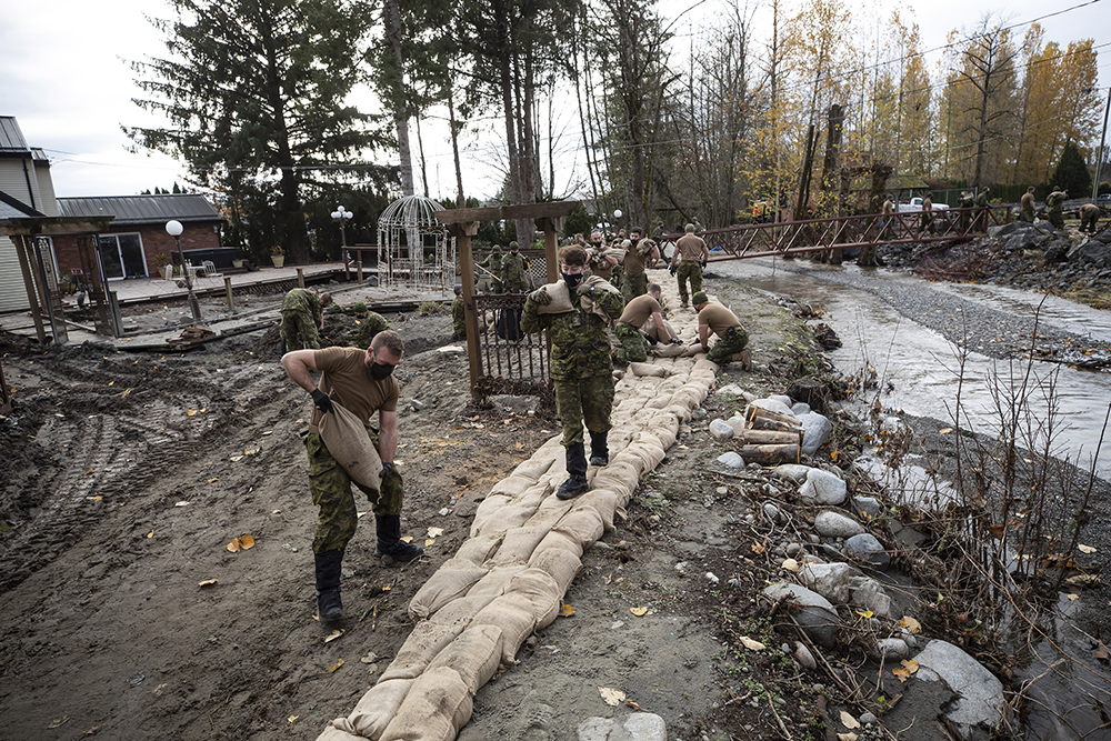 当地时间2021年11月24日，加拿大不列颠哥伦比亚省阿伯茨福德，加拿大环境部称，洪水已经对该地区造成了严重影响。在降雨预警前，加拿大部队成员正在运送沙袋，加紧建造临时堤坝。