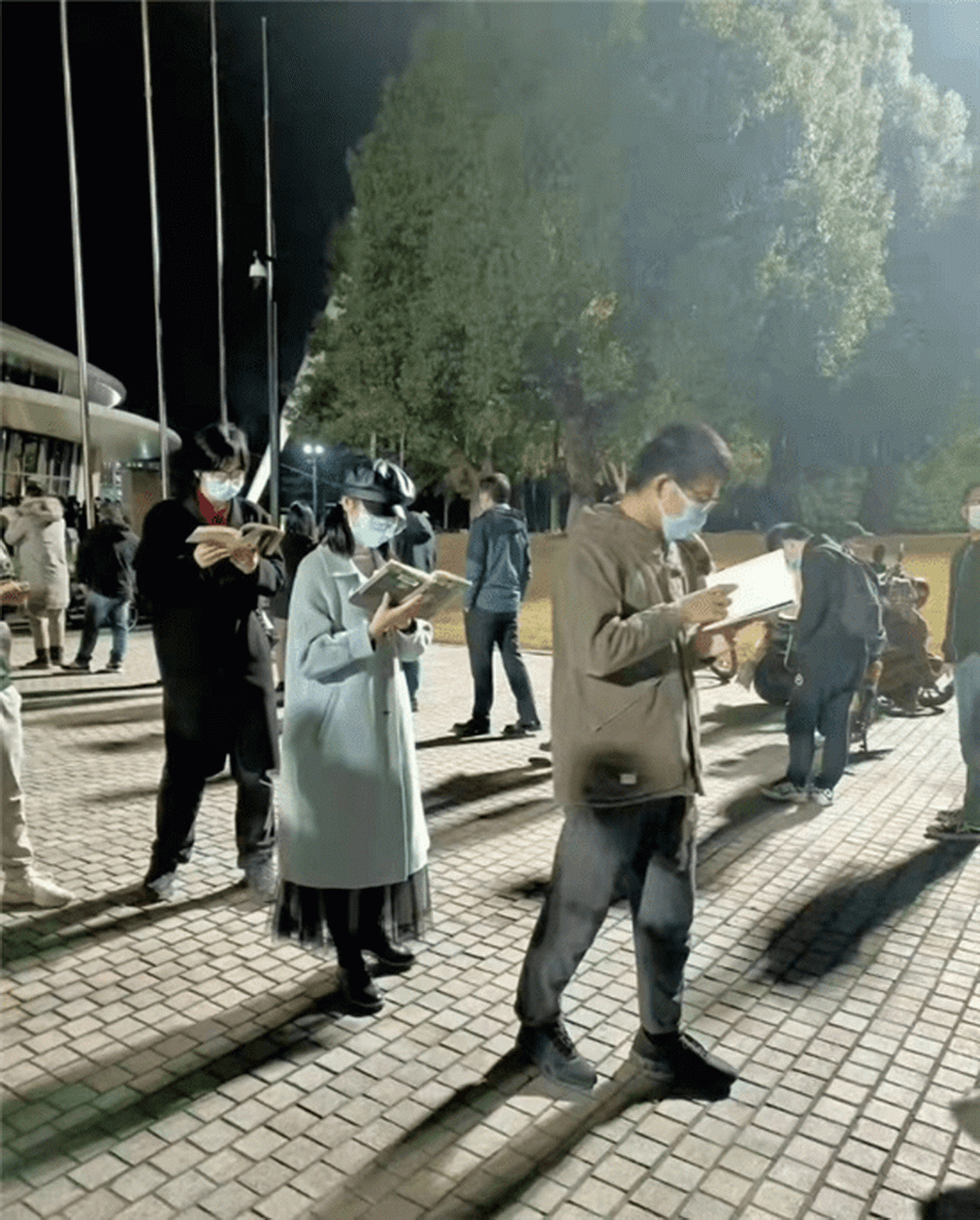 2021年11月25日晚，等候核酸检测过程中，浙大学霸边排队边看书。