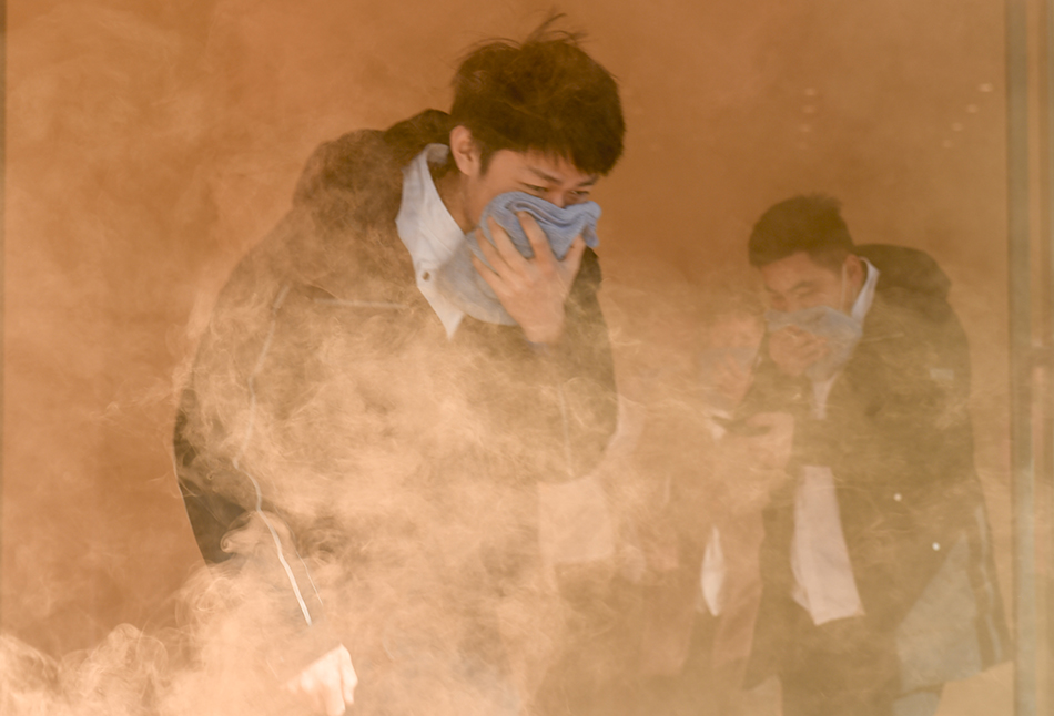 2021年11月24日，合肥，居民在酒店设置的浓烟中模拟逃生。11月是一年一度的”消防宣传月，今年消防宣传月的主题是“落实消防责任，防范安全风险”。李远波/视觉中国 图