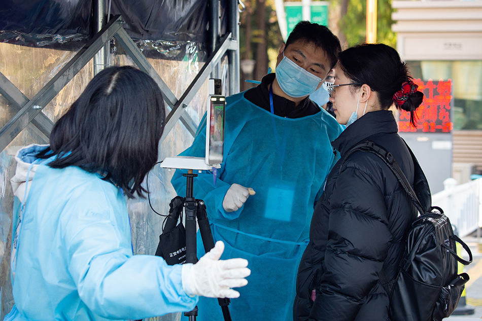 2021年11月28日，考生在南京林业大学考点门前测量体温并核验身份。 视觉中国 图