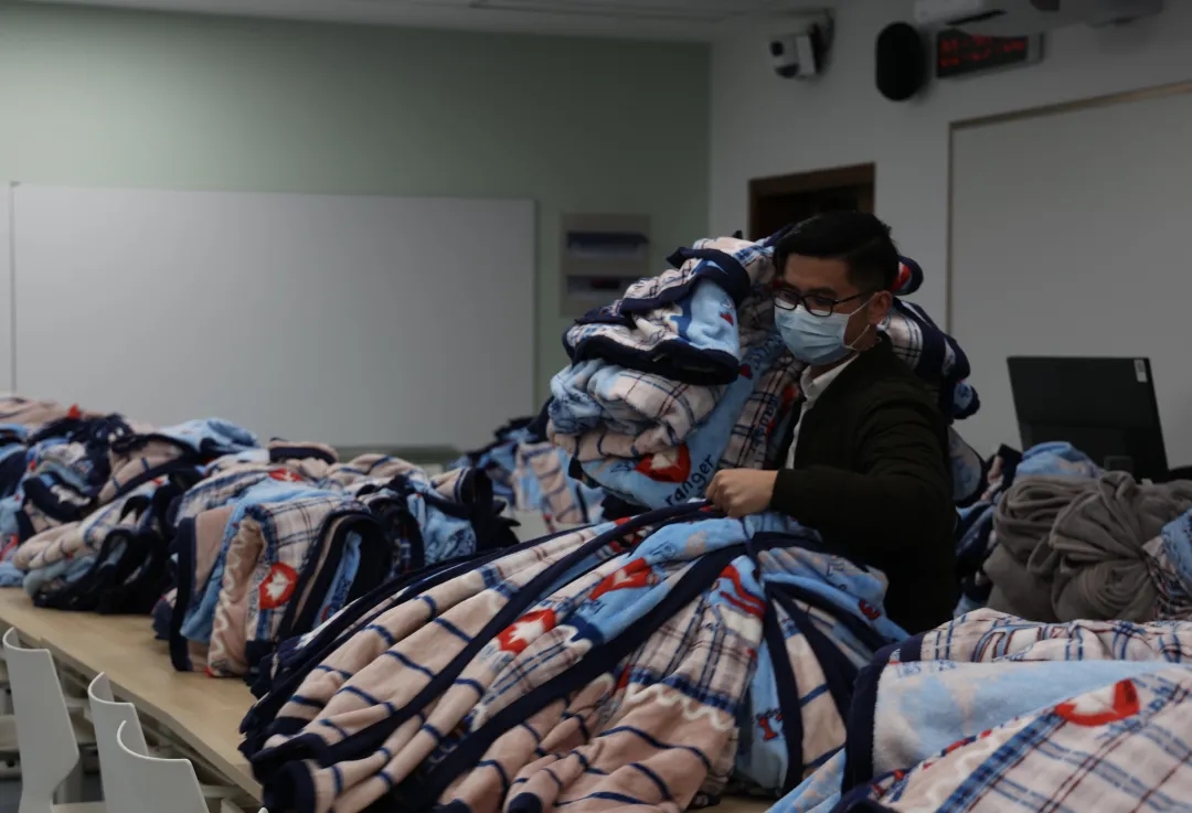 2021年11月26日凌晨，西一205教室中，工作人员为滞留者和师生准备毛毯。