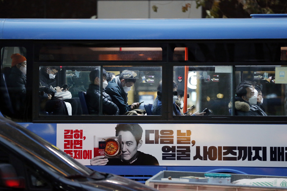 当地时间2021年11月29日，韩国首尔，佩戴口罩的市民在乘坐公交车。