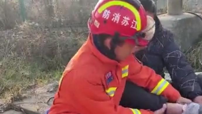 消防员解救被困积水区司机，买来鞋让他穿上保暖