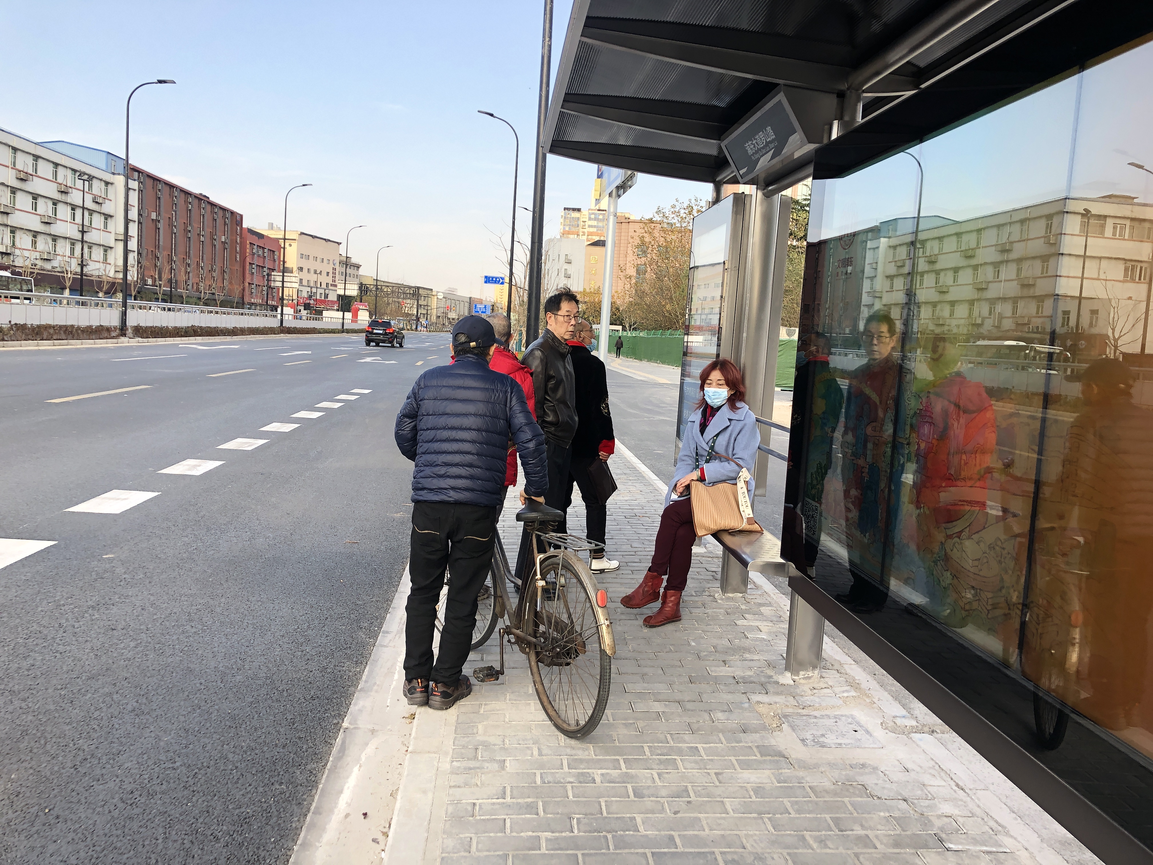 新的公交站台,有市民骑车来"踩点"公交新路线.