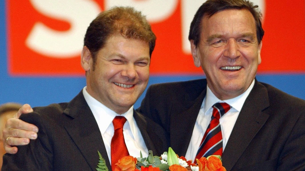 2002年，朔尔茨（左）当选社民党秘书长，接受施罗德的祝贺。