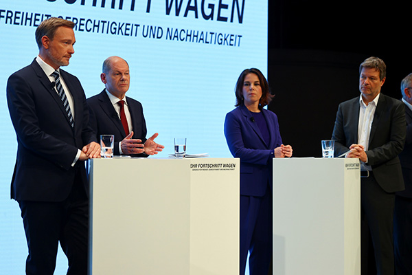 当地时间2021年11月24日，朔尔茨（左二）出席新闻发布会，宣布三党达成组阁协议。左一为自民党主席林德纳，左三、左四为绿党双主席贝尔伯克和哈贝克。  澎湃影像 资料图