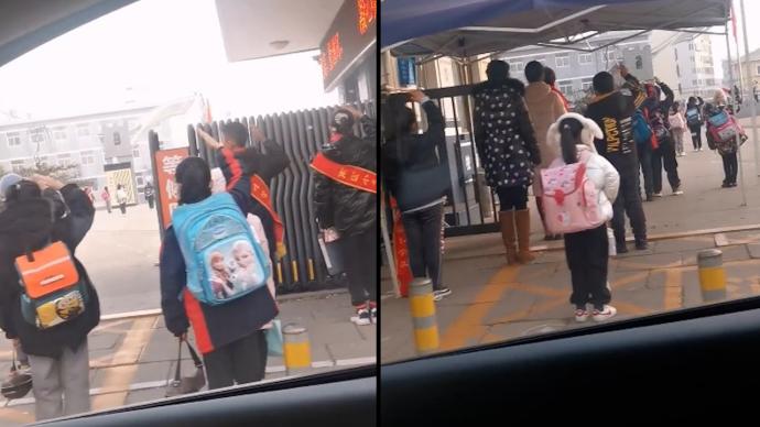 聽見國歌響起，小學(xué)生在校門口駐足敬禮