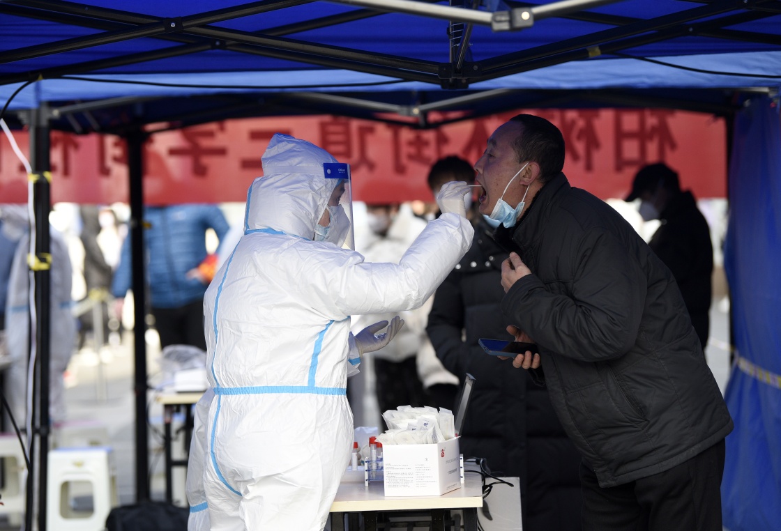 12月17日,市民在西安市碑林区柏树林街道三学街社区核酸检测点进行