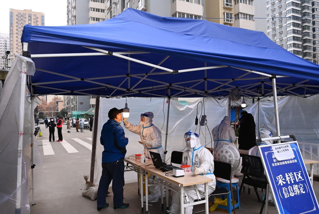 12月27日,在西安市碑林区张家村街道太白社区,居民在接受核酸检测