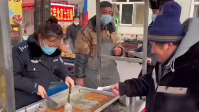 民警邊幫攤主煎土豆餅邊進(jìn)行防詐騙宣傳