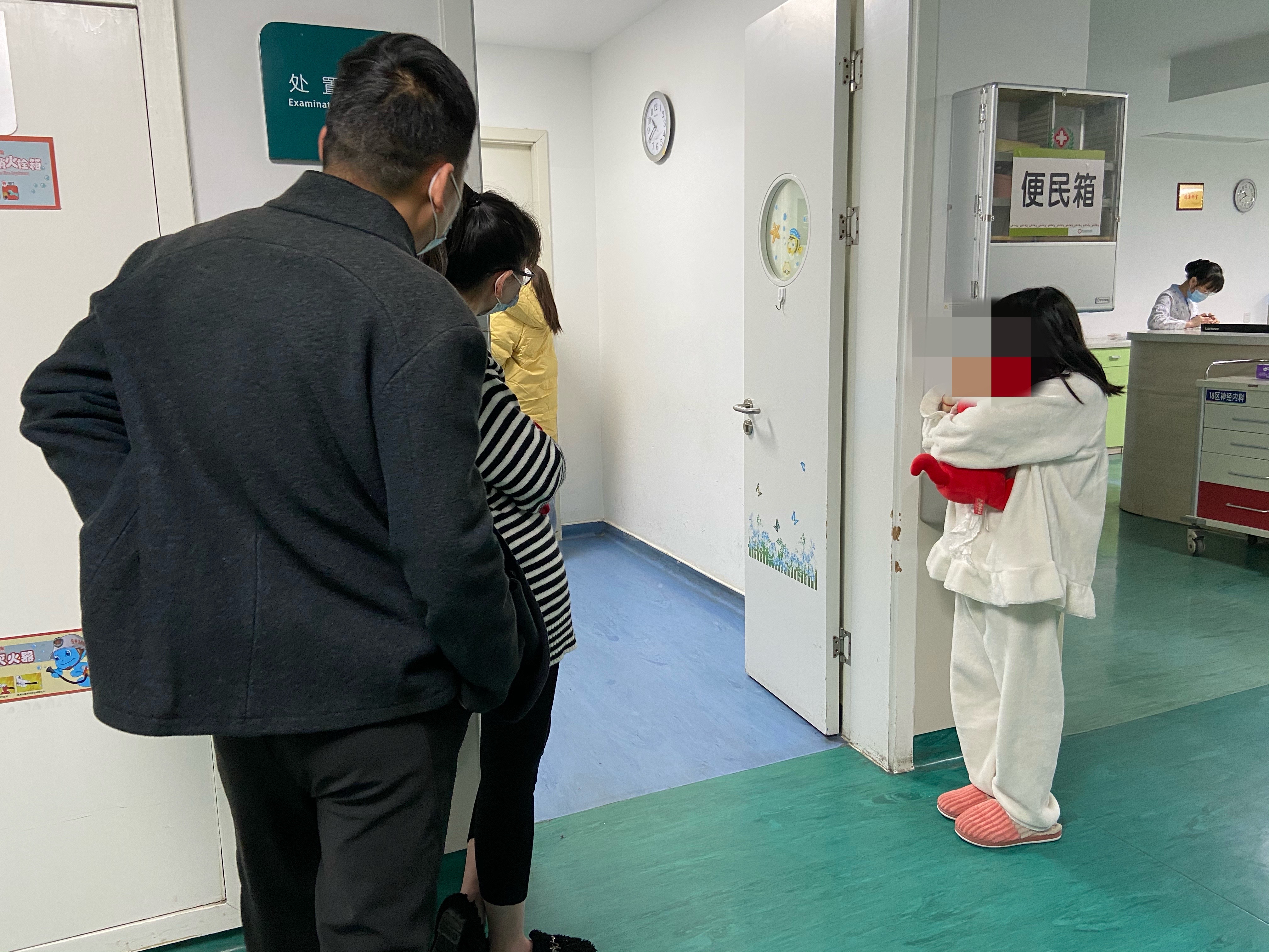 馨馨的爸爸妈妈正在焦急等待，结识不久的隔壁病床姐姐抱着馨馨喜爱的玩偶。澎湃新闻记者贺梨萍 图