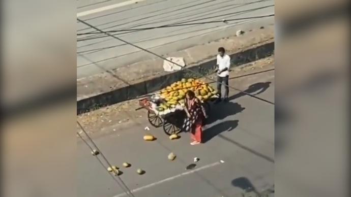 印度一女子驾车与小贩碰擦，当街连续狠砸摊贩货品