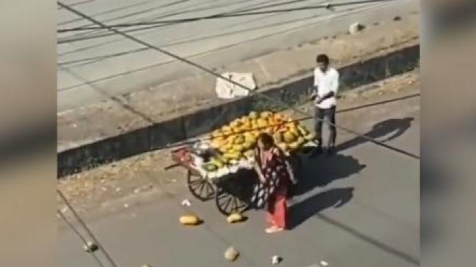 印度一女子驾车与小贩碰擦，当街连续狠砸摊贩货品