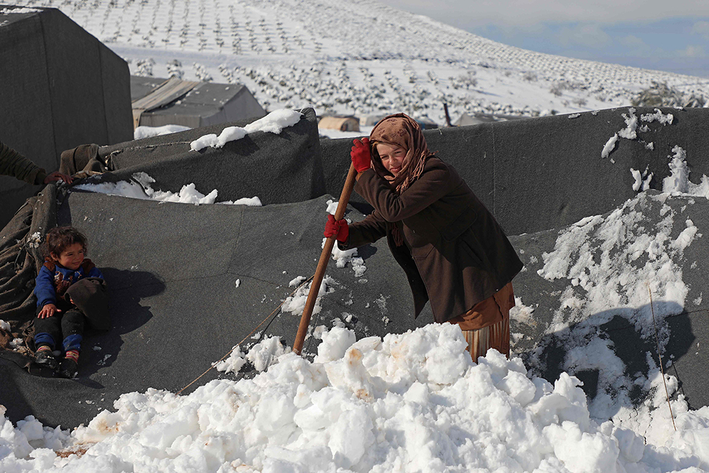 当地时间2022年1月19日，叙利亚阿勒颇，当地降雪，难民营地周边覆满积雪，孩童雪中玩闹。