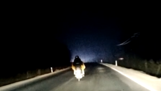 女子骑摩托车夜行，夫妻开车跟在后面为她照路