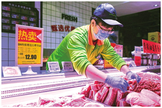 在北京市海淀区一家超市，工作人员码放鲜肉（2021年12月31日摄）。新华社记者任超摄
