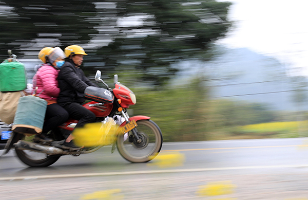 2022年1月20日，返乡农民工驾驶摩托车行驶在国道209线广西柳州市融安县浮石镇路段。人民视觉 图